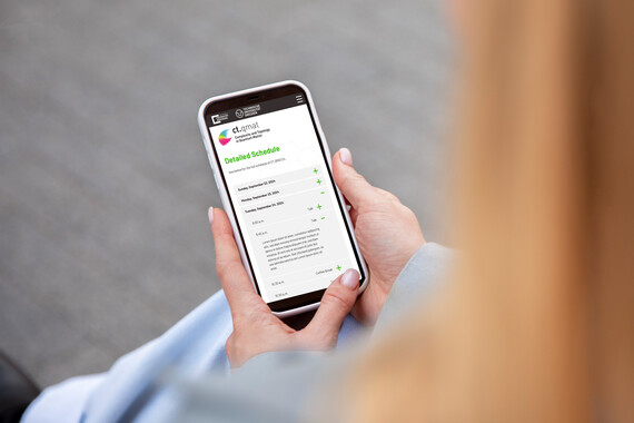 Smartphone in one hand, on which the detailed timetable of ctqmat24 is teasered
